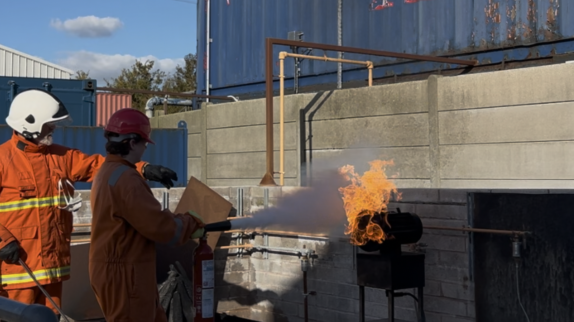Cadets using fire extinguishers to put out flames in a controlled environment