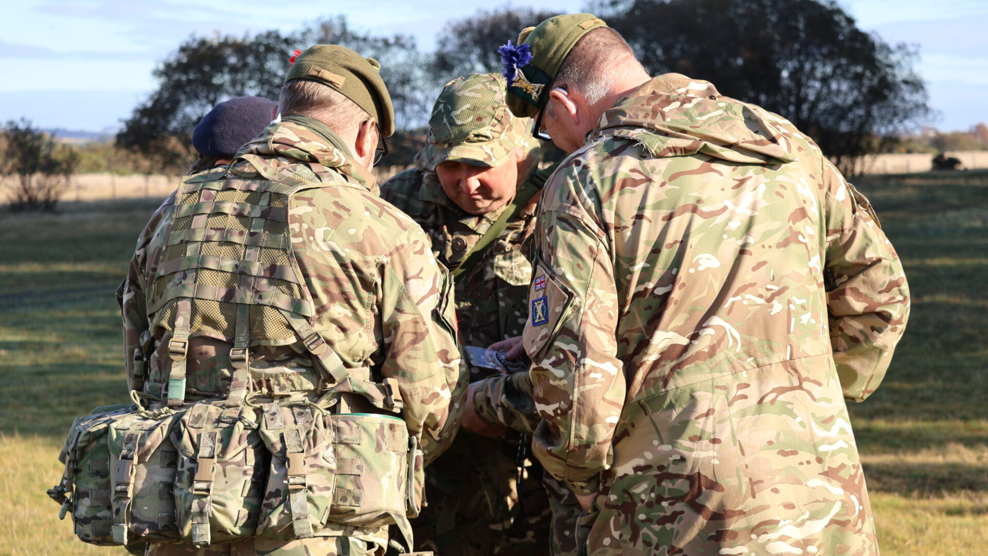 Cadet Force Adult Volunteers huddling around a map
