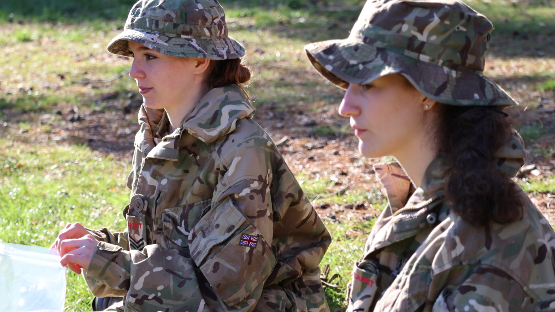 CCF cadets sitting down and listening in a field