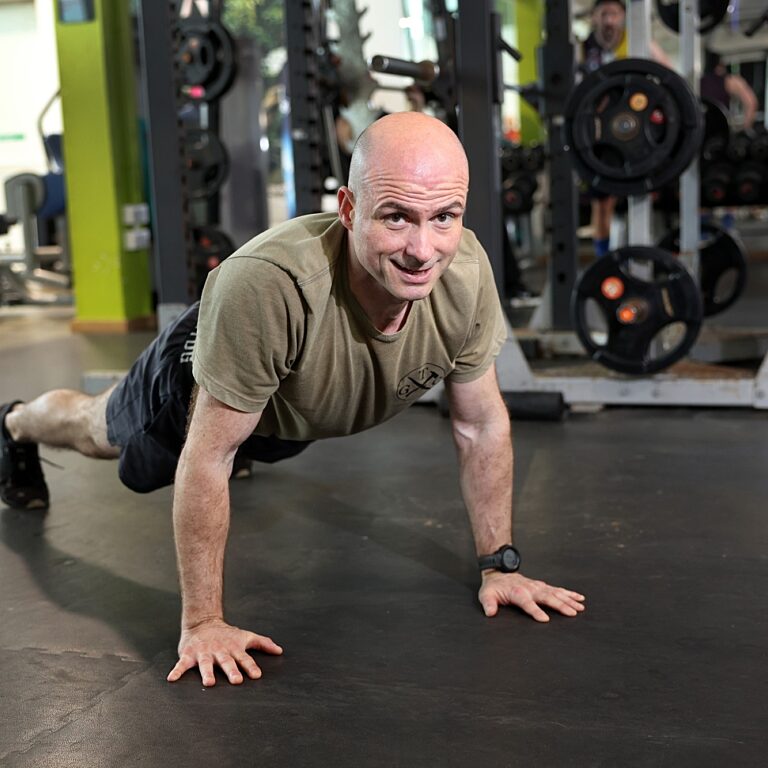 Adult volunteer doing push ups in a gym