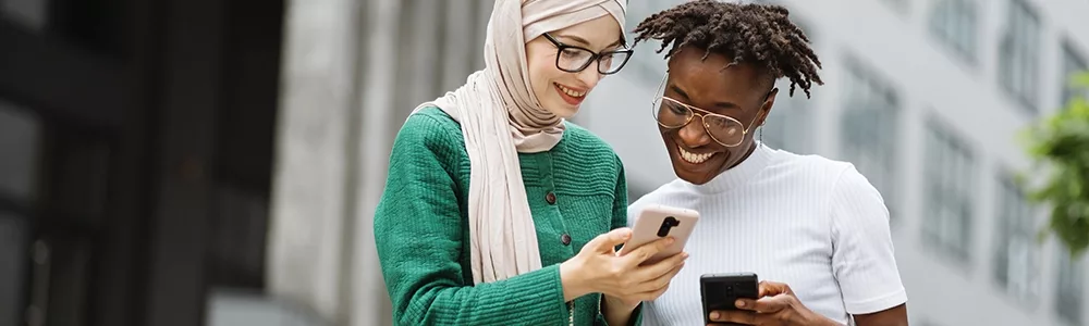 Friends looking at phone 1000x300