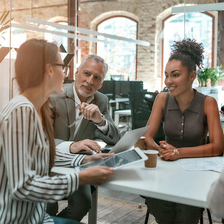 Team meeting in a modern office with colleagues collaborating around a table | Amodaia