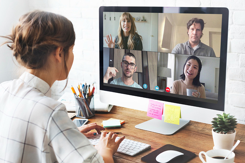 Woman in online video meeting with four colleagues on computer screen | Amodaia