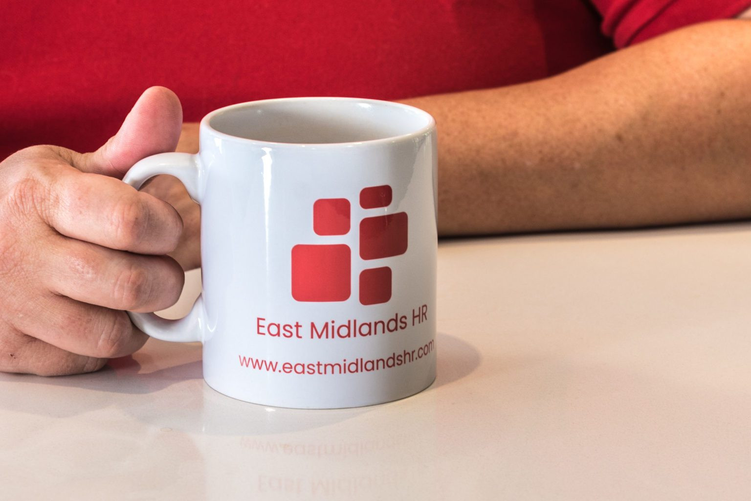 About East Midlands HR - holding a mug