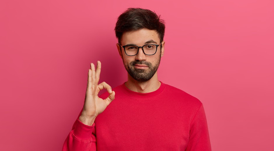 blog no words.jpg man with pink jumper holding fingers in okay sign