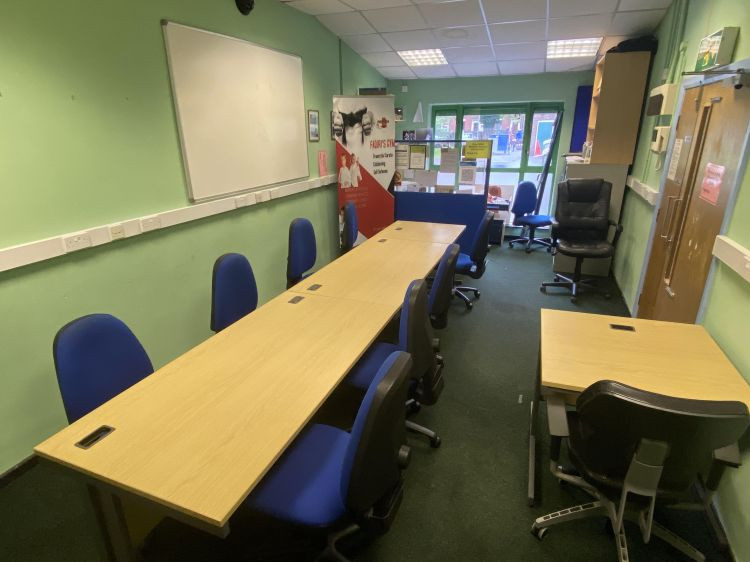 Small meeting room with long tables, blue chairs and a whiteboard, perfect for workshops, training sessions and community meetings | Catherine Beckett Community Centre
