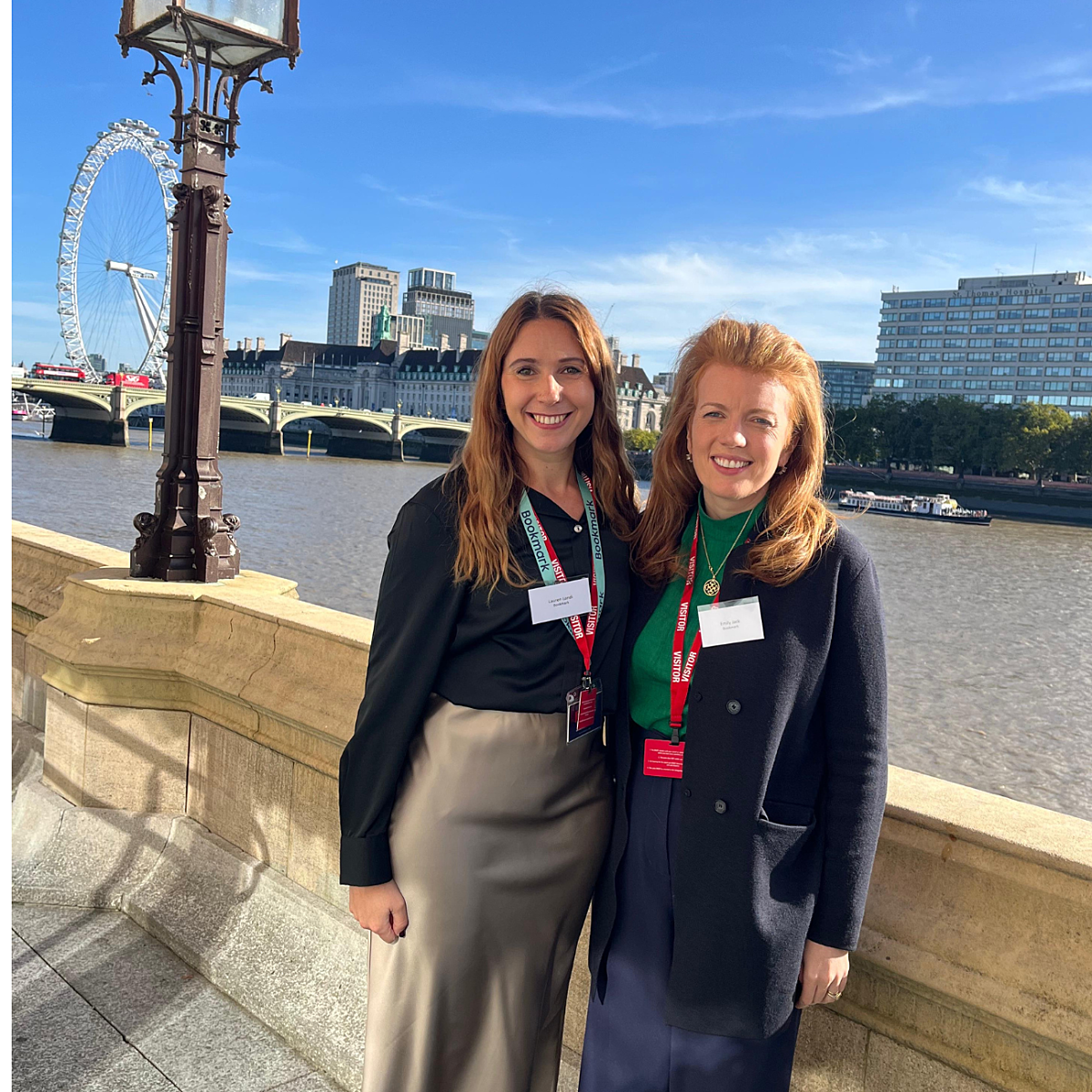 Bookmark's head of schools and CEO standing in front of the London Eye, smiling at the camera