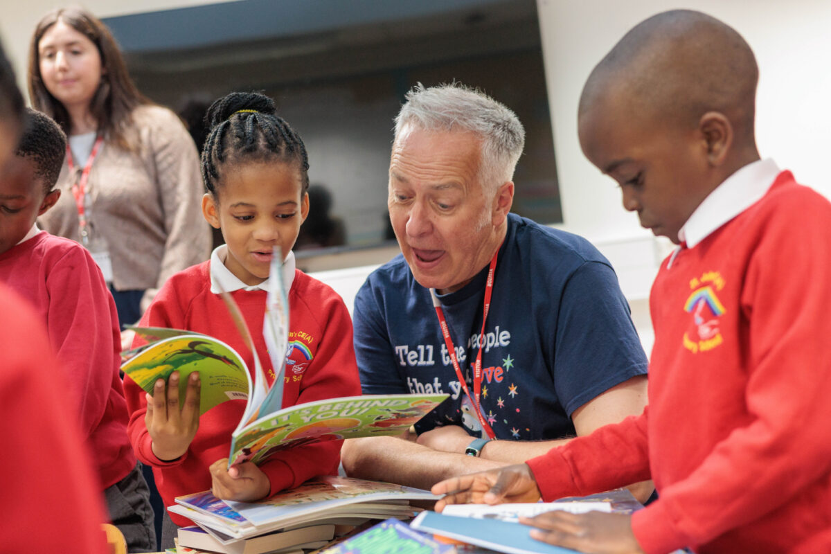 Childrens author reading a book with two children.