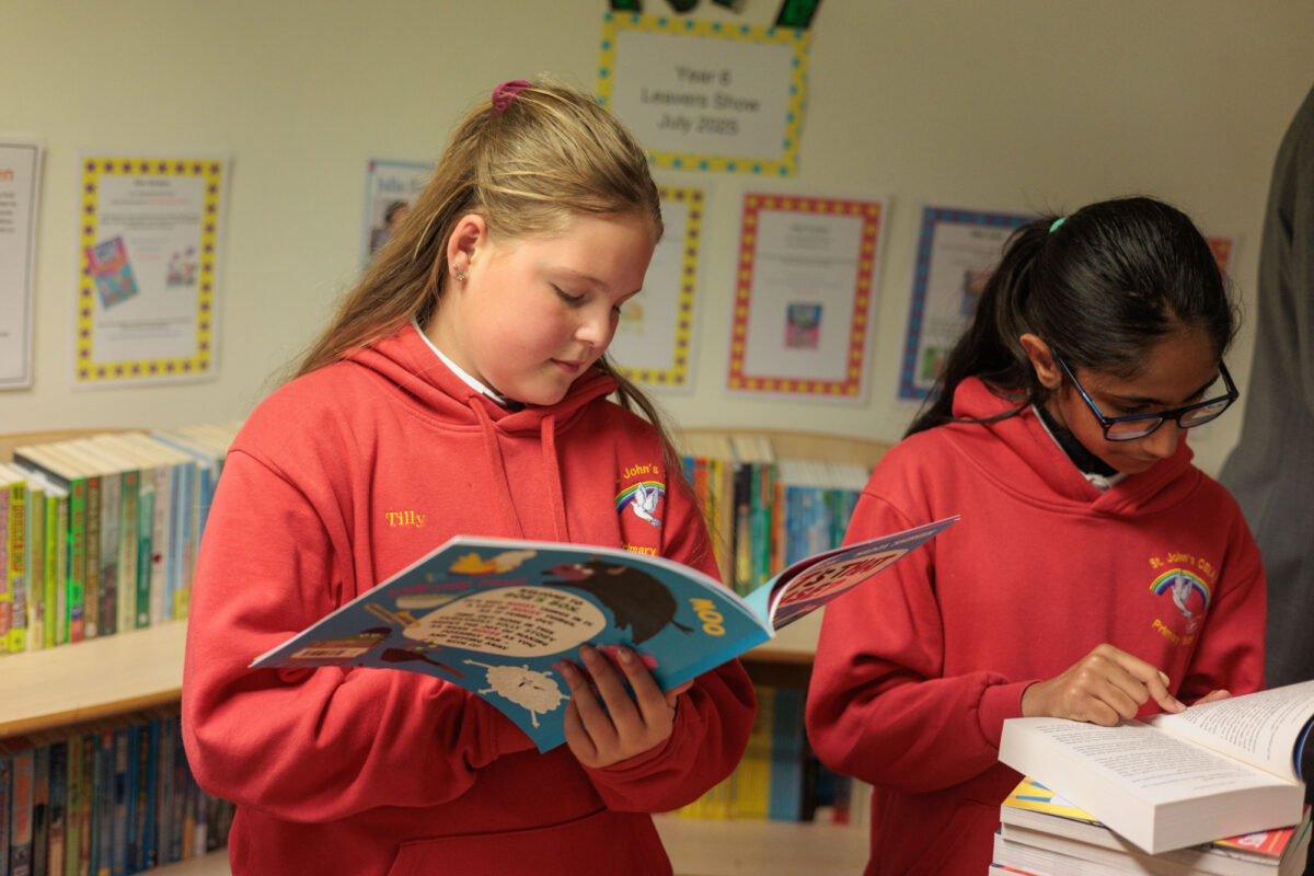 Two children reading a book from Bookmark's roots to reading programme pack.