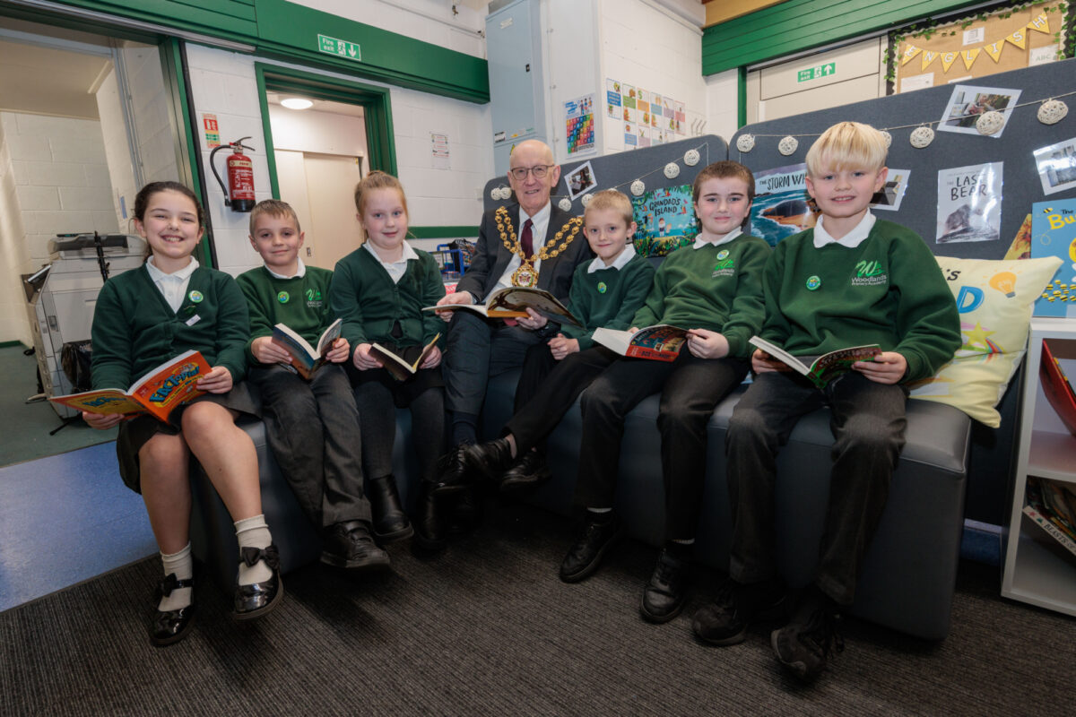 Pupils at Woodlands Primary Academy sitting with the Major of Oldham, holding books from their Your Story Corner pack.