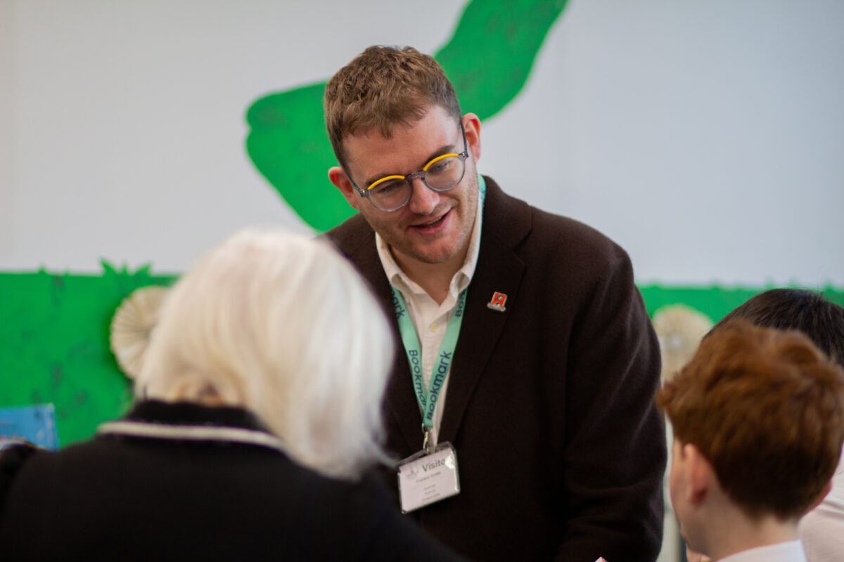 A man in a brown jacket smiles at a child.