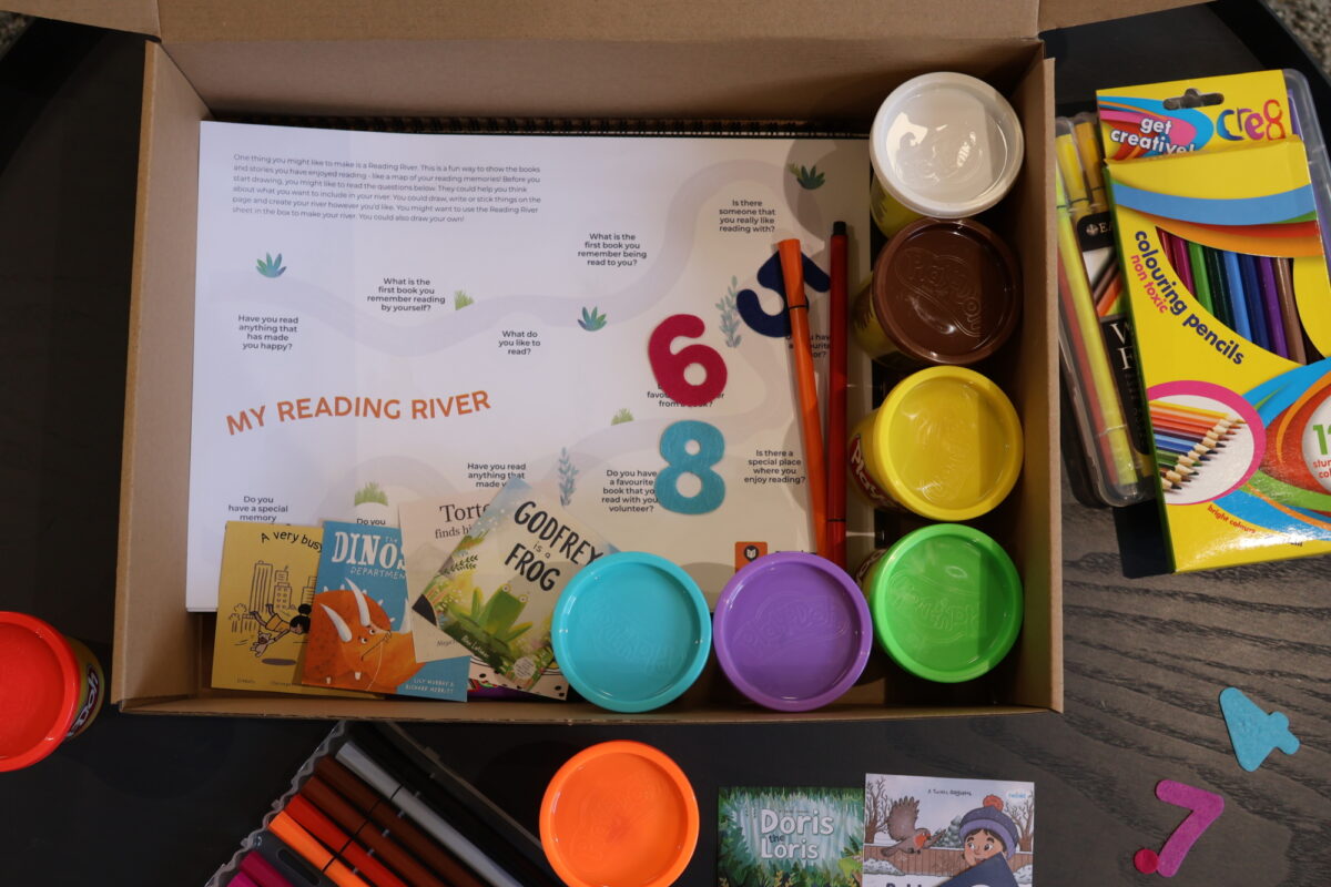 Box with different activities like play dough, colouring pens and an activity sheet