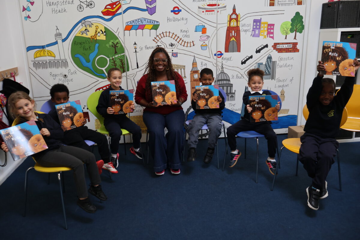 Children in a group at Pakeman Primary holding signed books from Tola Okogwu.