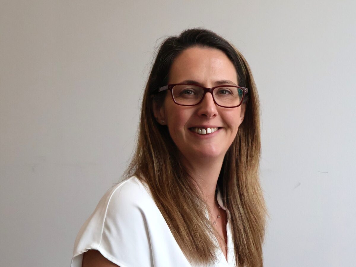 Bookmark trustee with brown hair and glasses smiling at the camera