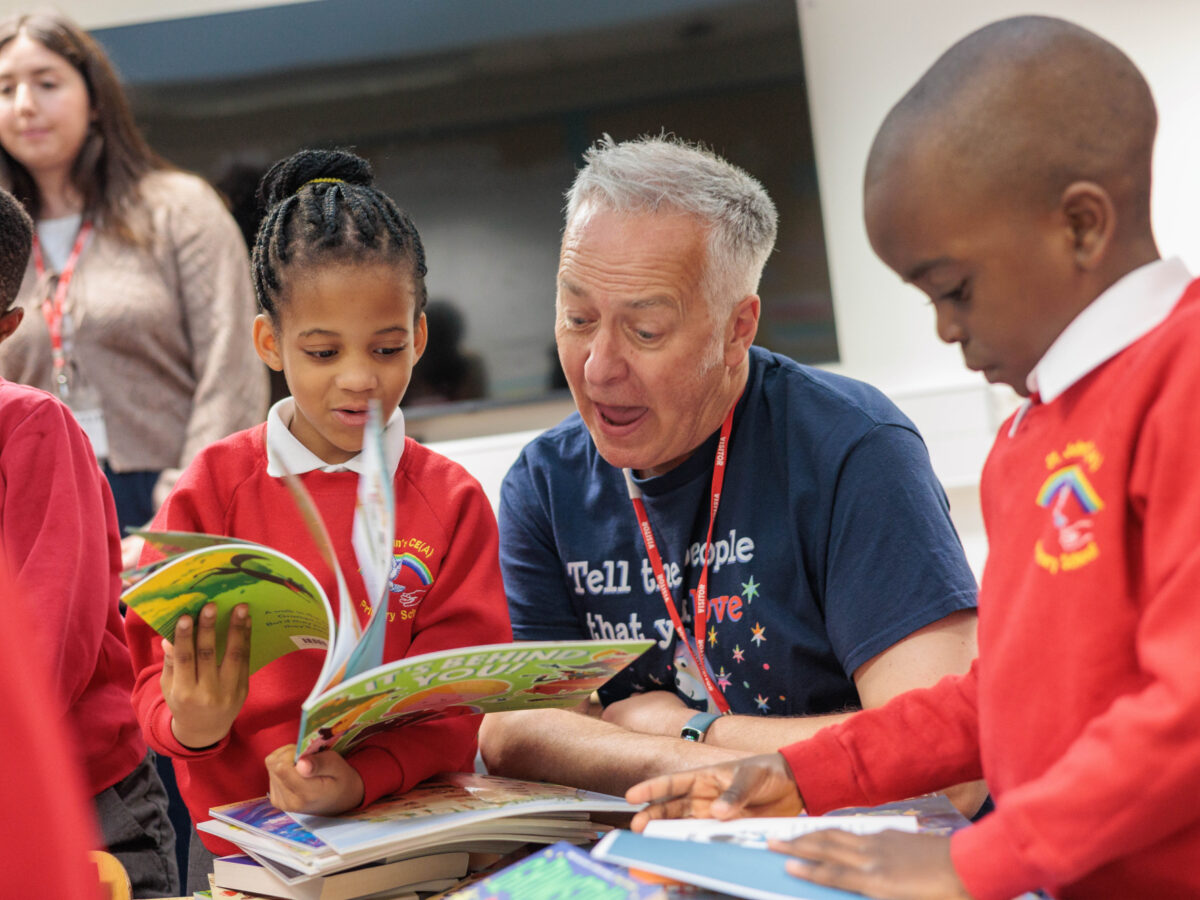 Childrens author reading a book with two children.