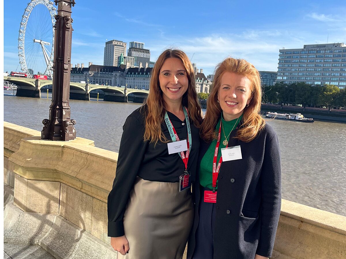 Bookmark's head of schools and CEO standing in front of the London Eye, smiling at the camera