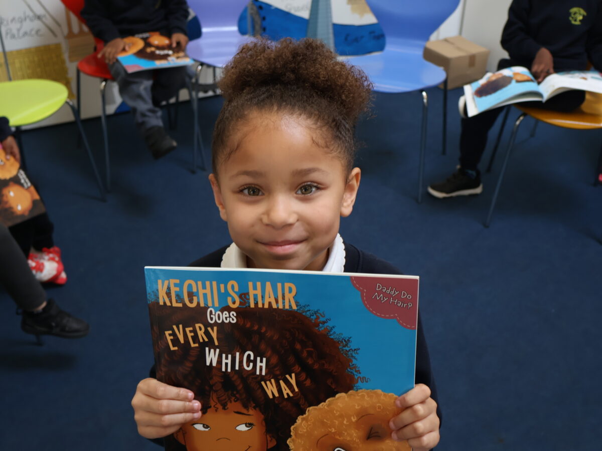 Child holding Kechi’s Hair Goes Every Which Way at Pakeman Primary School during a storytelling session with author Tola Okogwu.