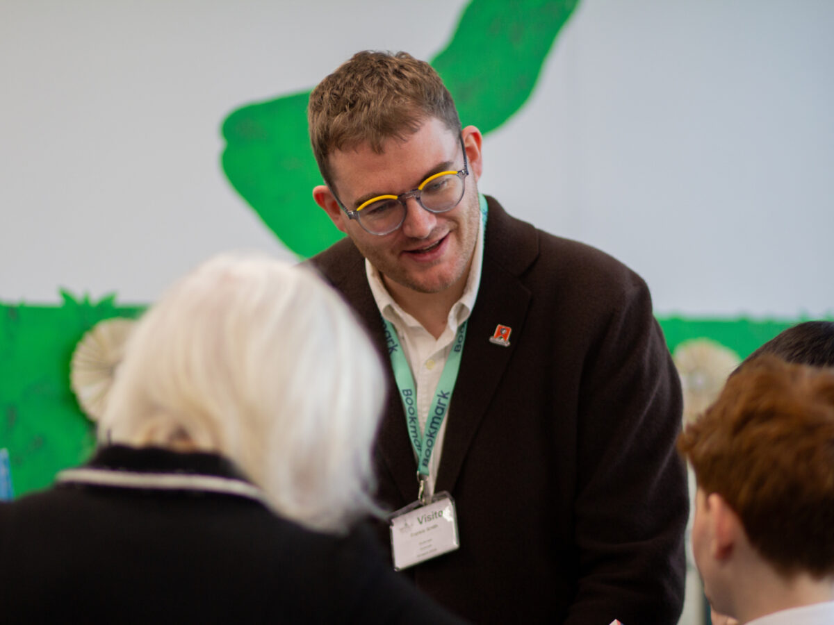 A man in a brown jacket smiles at a child.