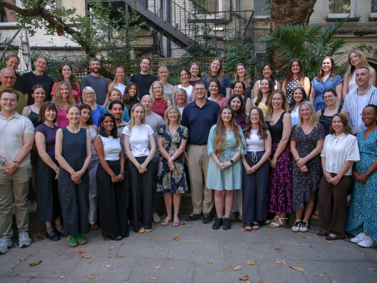 Bookmark team members gathered for a group photo in an outdoor courtyard surrounded by trees and historic buildings.