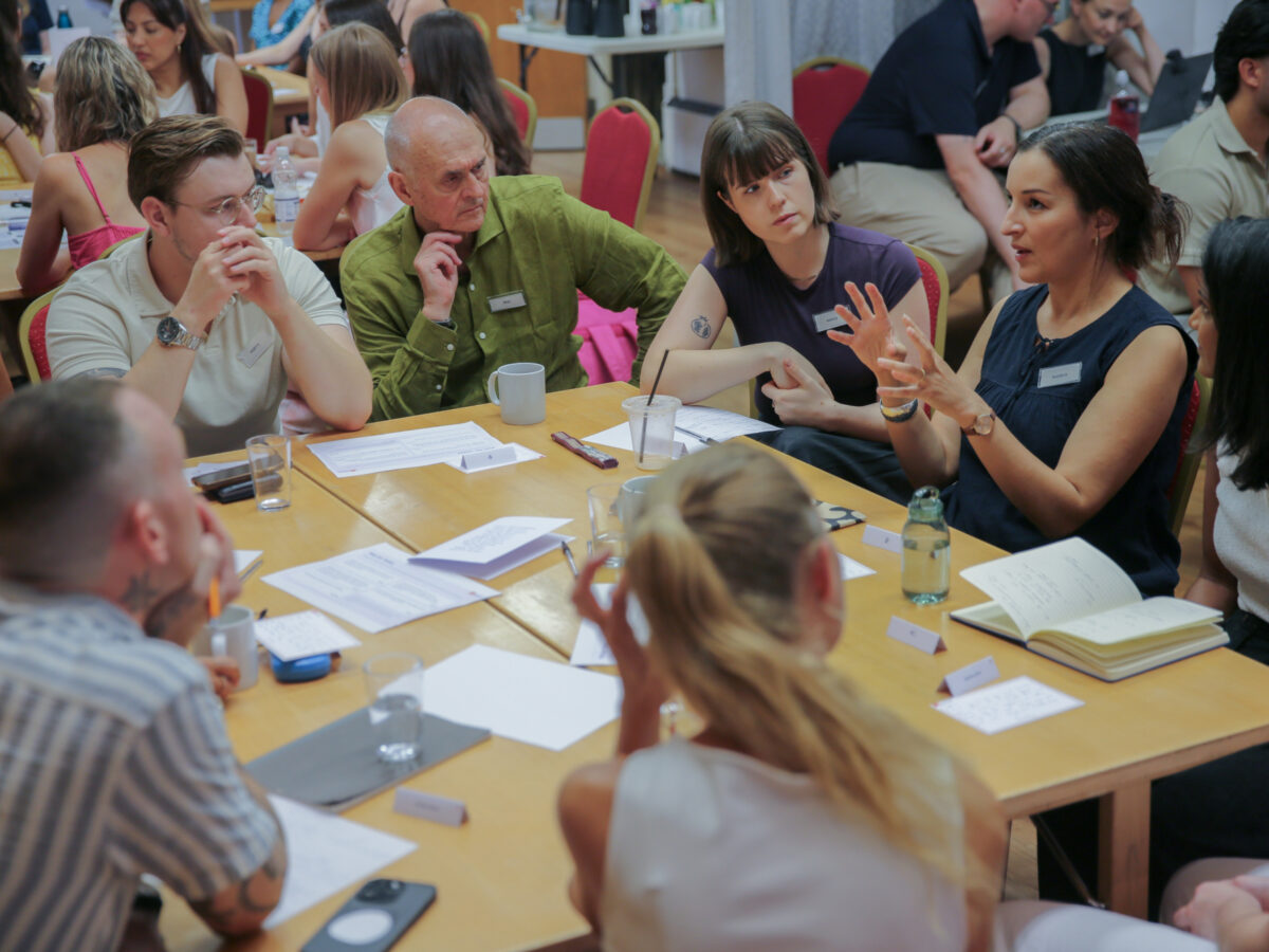 Team members seated around tables taking part in a group discussion during a team day workshop.