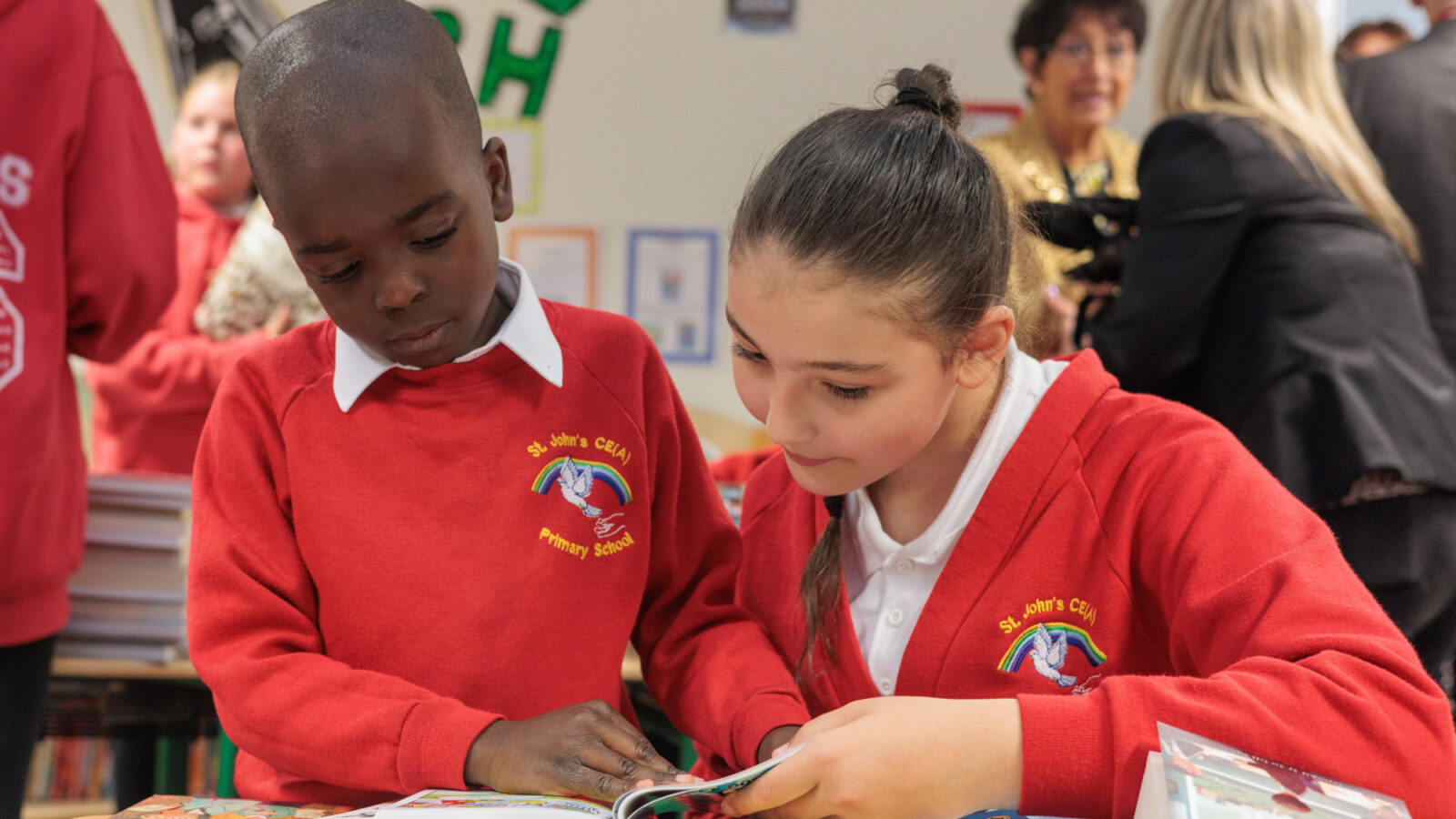 Two children reading a book from Bookmark's roots to reading programme pack.