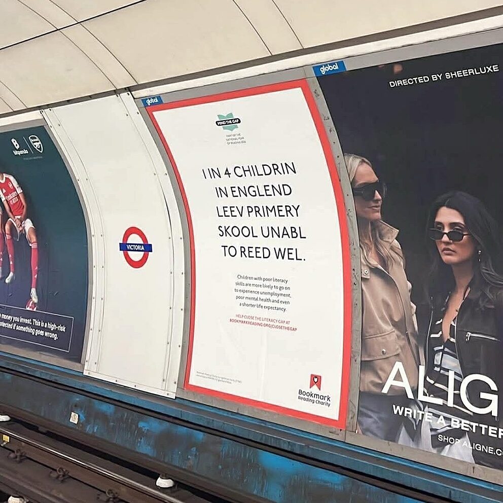 London Underground posters including a Bookmark Mind the Gap campaign ad stating many children in England leave primary school unable to read well.