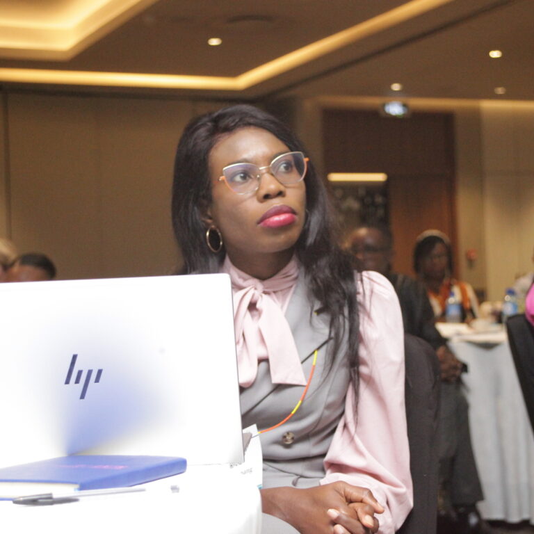 a photo of ruth at a conference watching someone present out of shot