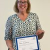 Photo of Research Ethics Committee member Sue Fitzpatrick holding a certificate for 10 years of service.